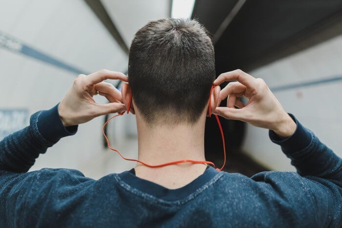 A stock image of a man listening to music in the context of social media monitoring and social media wall 