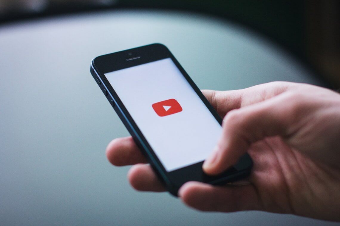 una persona sostiene un smartphone con la aplicación youtube abierta