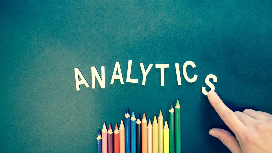 word analytics written on a green board with crayons underneath
