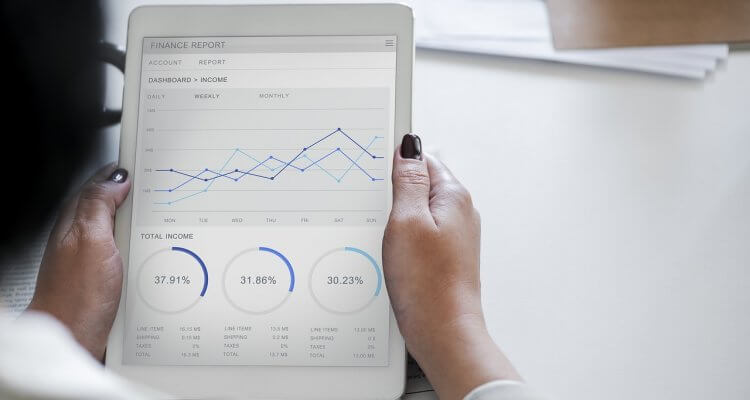 a woman holding an iPad with graphs and charts on it 