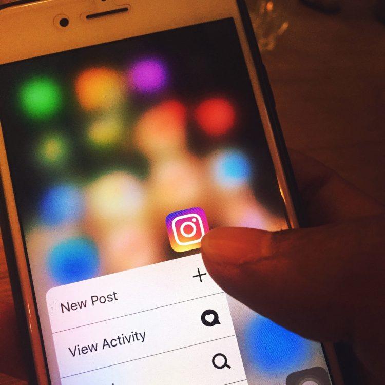 a person holding a smartphone with Instagram app open