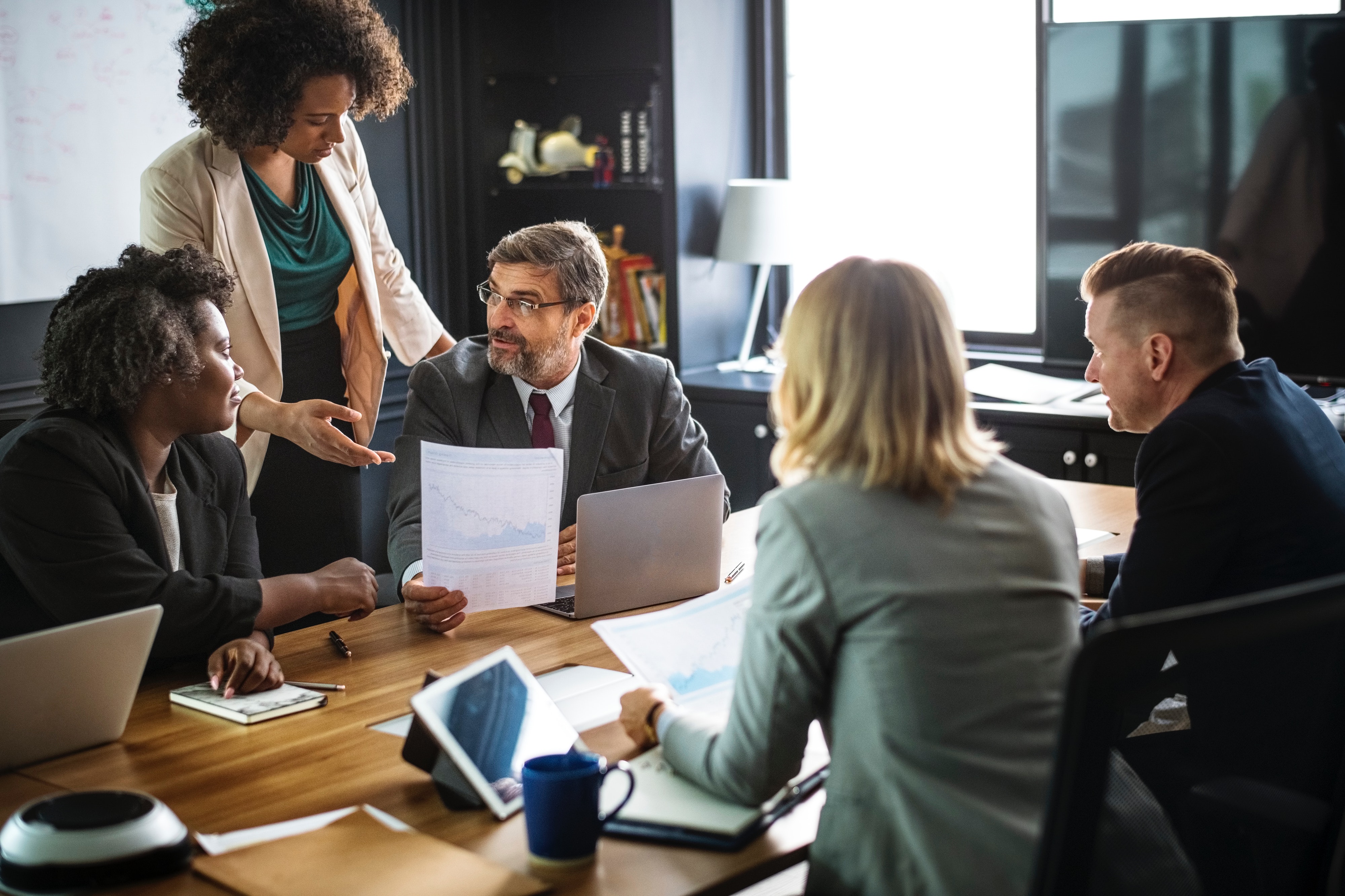 employees standing around a table in a meeting