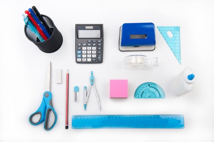 calculator and other office supplies on a white table 